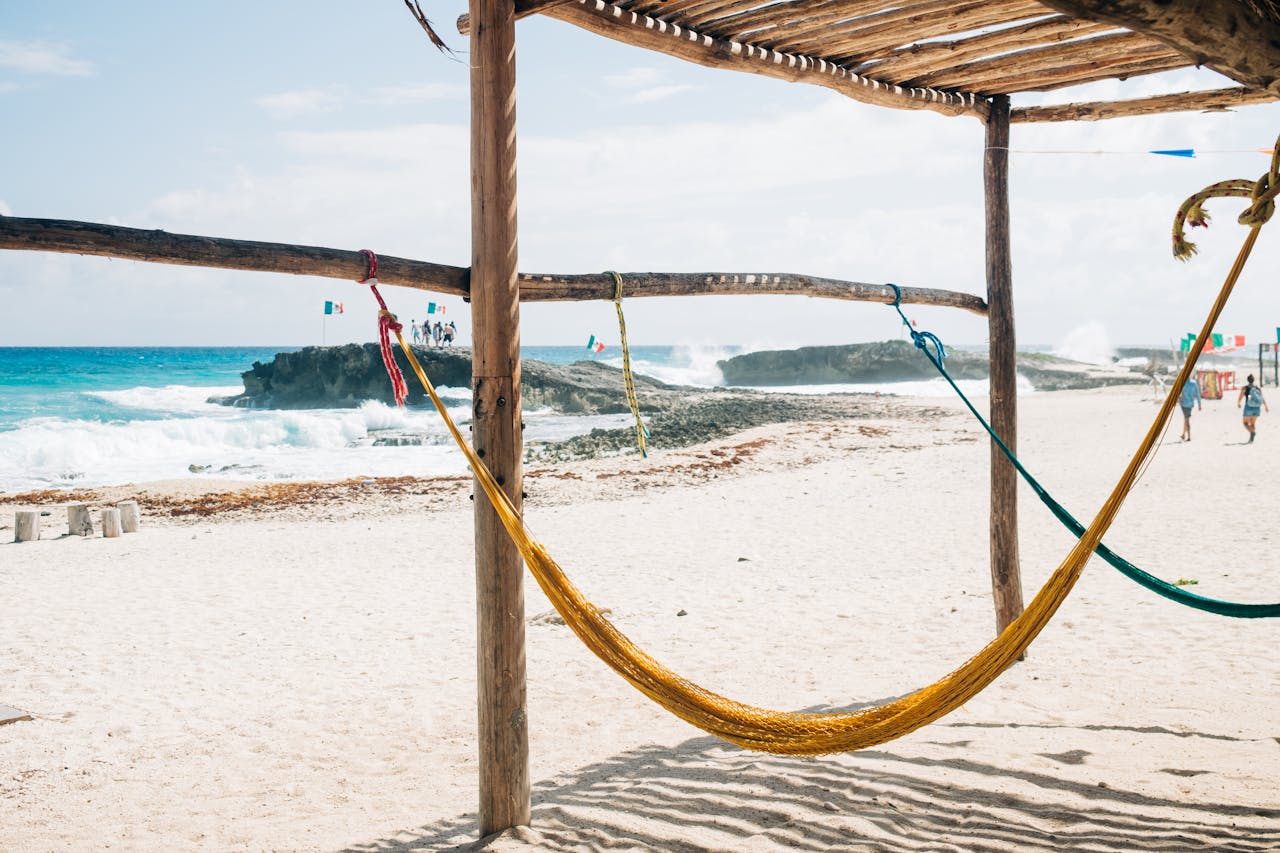 Relaxing hammock scene on a sandy beach in Cozumel, Mexico with a stunning coastal view.